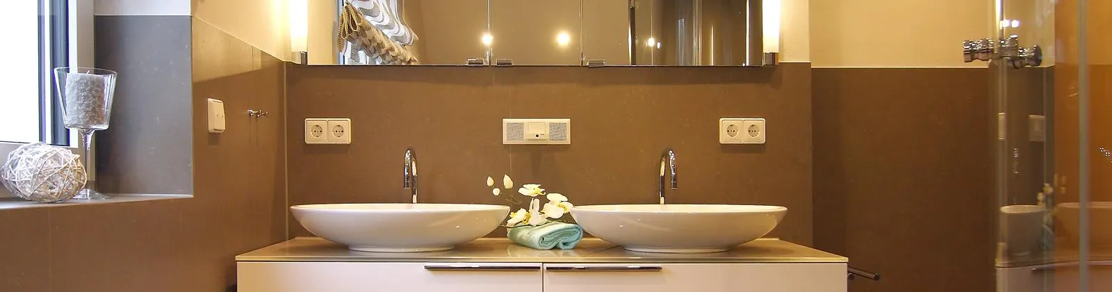 Modernes Gästebad mit Doppelwaschtisch, Aufsatzwaschbecken, großem Spiegel und eleganter Beleuchtung.