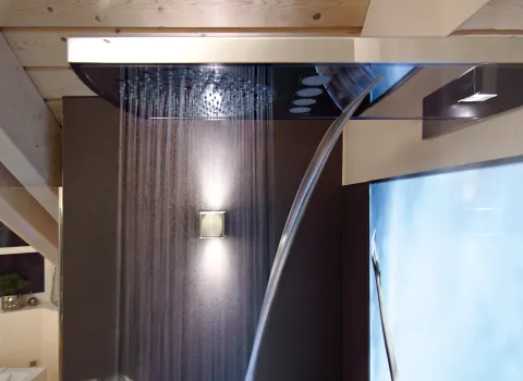 Moderne Regendusche mit Wasserfallfunktion in einem luxuriösen Badezimmer, kombiniert mit stilvoller Beleuchtung und Wohlfühlambiente.