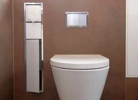 Modernes Wand-WC mit integrierter Spülung und schmalem, platzsparendem Toilettenpapierfach in eleganter Badgestaltung.