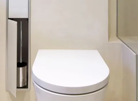 Modernes wandhängendes WC mit integrierter, diskret verbauter WC-Bürste im minimalistischen Badezimmer-Design.