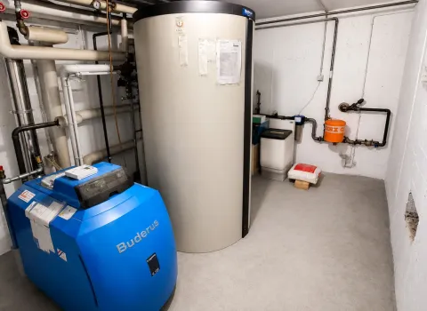 Technikraum mit energieeffizientem Buderus Heizsystem, großem Wärmespeicher und professioneller Installation. Die Kombination aus Heizkessel, Pufferspeicher und hydraulischen Komponenten ermöglicht eine nachhaltige und komfortable Wärmeversorgung.