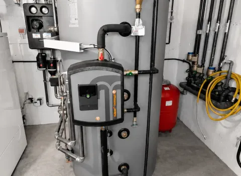 Heizungsanlage mit großem Pufferspeicher, Frischwasserstation und intelligentem Hydrauliksystem in einem Technikraum. Die Kombination aus Wärmespeicherung und bedarfsgerechter Warmwasserbereitung unterstützt einen nachhaltigen und wirtschaftlichen Heizbetrieb.