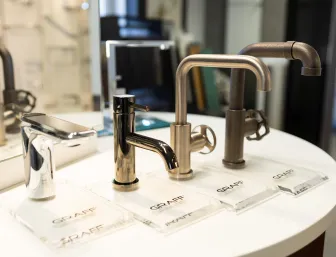 Präsentation hochwertiger Waschtischarmaturen der Marke GRAFF in unterschiedlichen Oberflächen und Designs auf einer Ausstellungsfläche der Stübler GmbH.