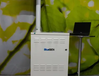BlueGEN-Brennstoffzelle zur Eigenstrom- und Wärmeversorgung mit Infotafel, ausgestellt bei der Stübler GmbH vor einem großformatigen Naturmotiv.