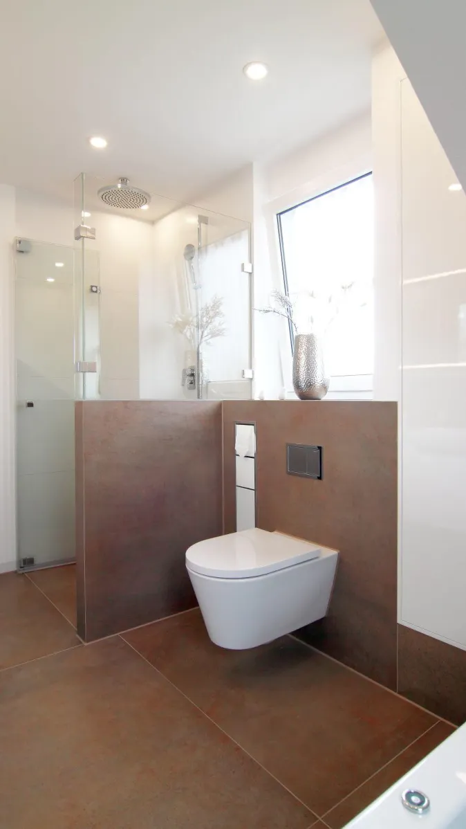 Modernes Badezimmer mit bodengleicher Glasdusche, Wand-WC und großem Fenster, gestaltet in warmen Naturtönen.