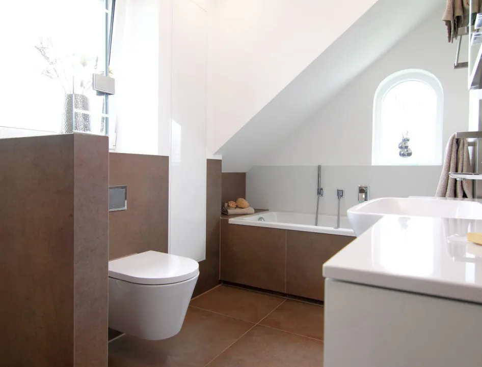 Modernes Badezimmer im Obergeschoss mit Badewanne unter Dachschräge, Wand-WC, stilvollem Waschtisch und heller Gestaltung.