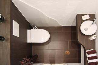 Gaeste WC mit dunklen Holzflächen, weißem WC und Waschbecken