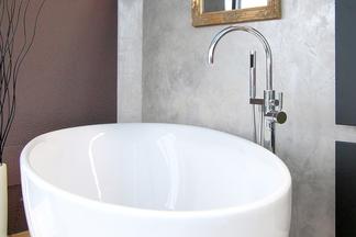 Freistehende ovale Badewanne mit auf dem Boden stehender Aramtur.