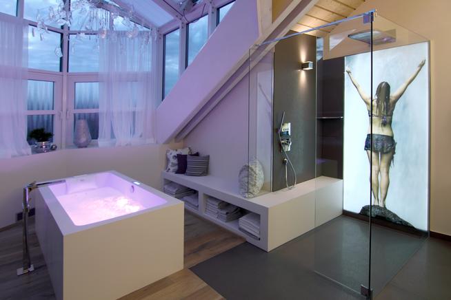 Whirlwanne mit LEDs und Dusche mit hinterleuchtetem Wandbild