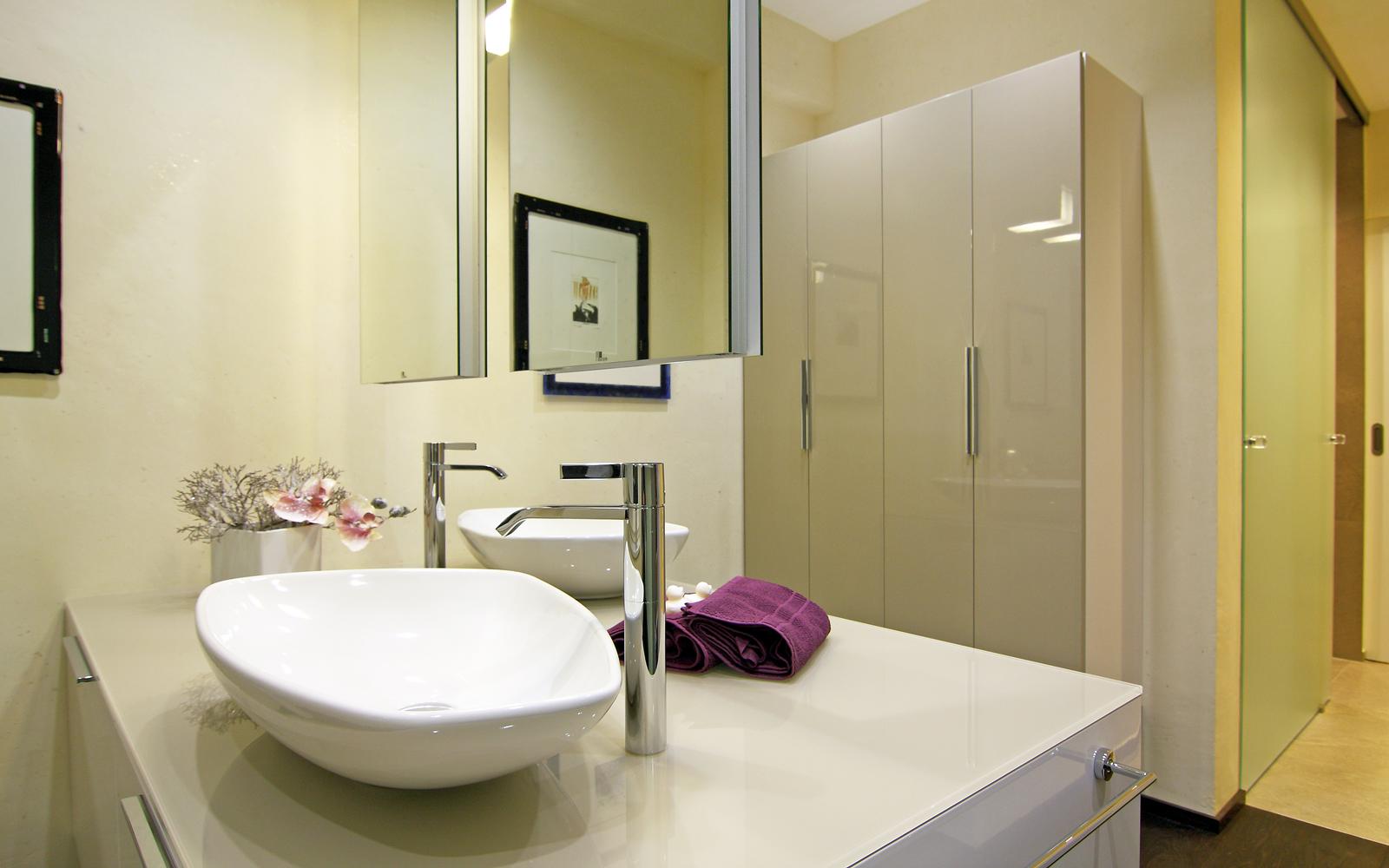 Wohnbad mit großem Waschtisch und Wandschrank.