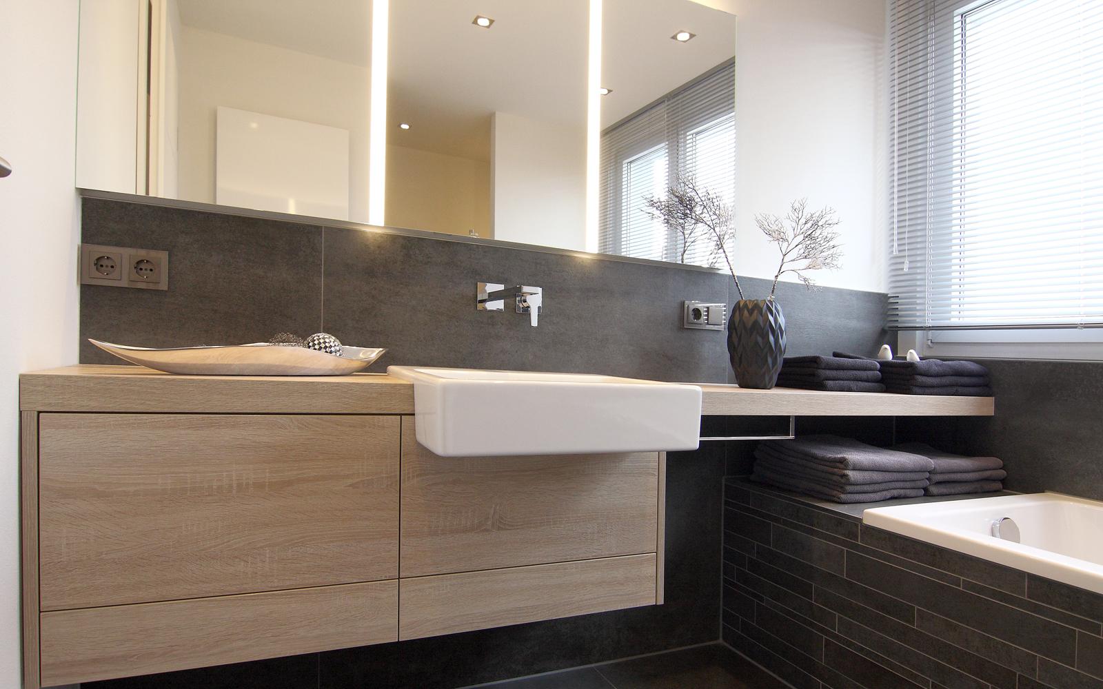 Großer Waschtisch mit großen Spiegeln und angrenzender Badewanne.