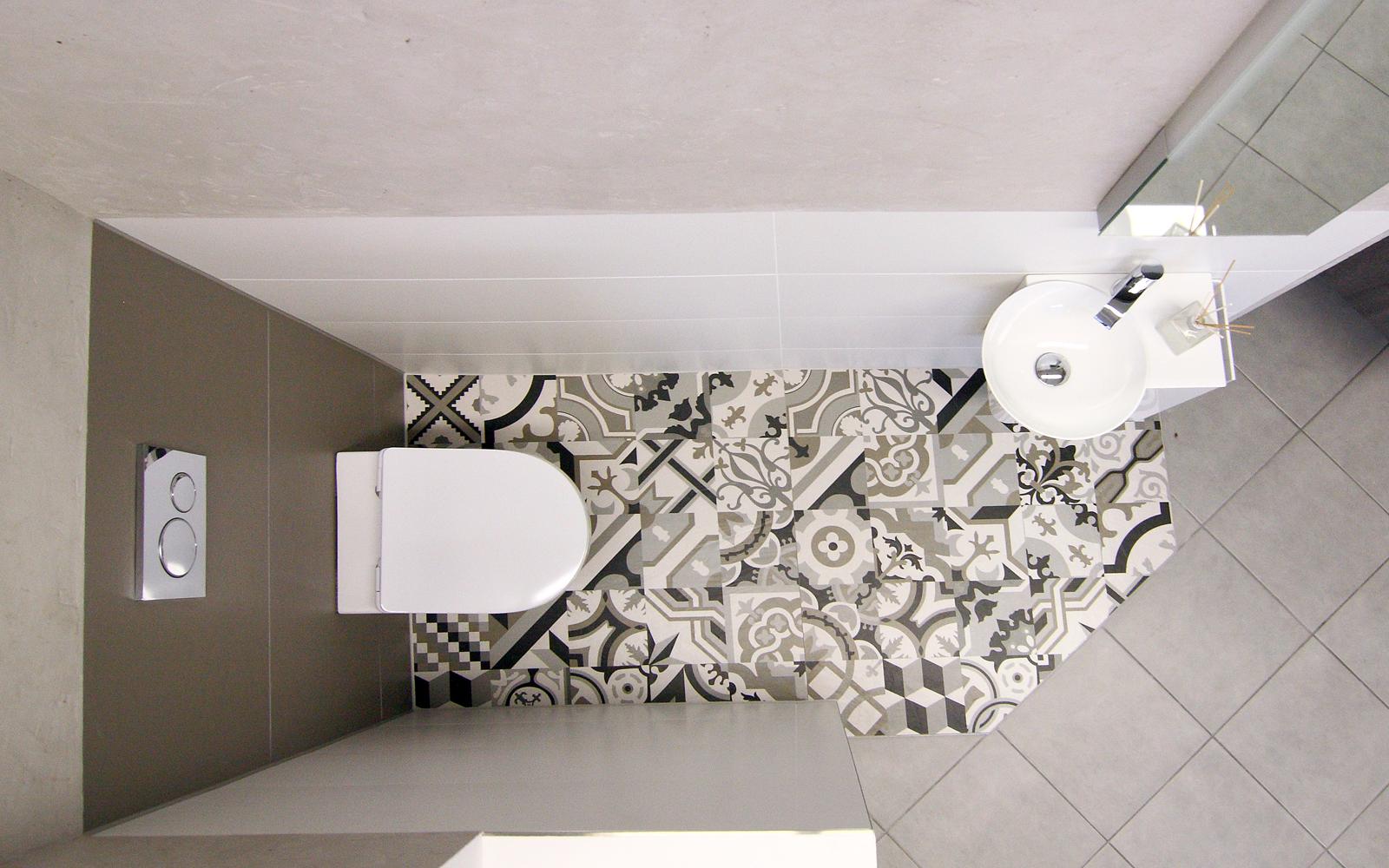 Gäste WC mit runden Waschbecken und Motivfliesen am Boden.
